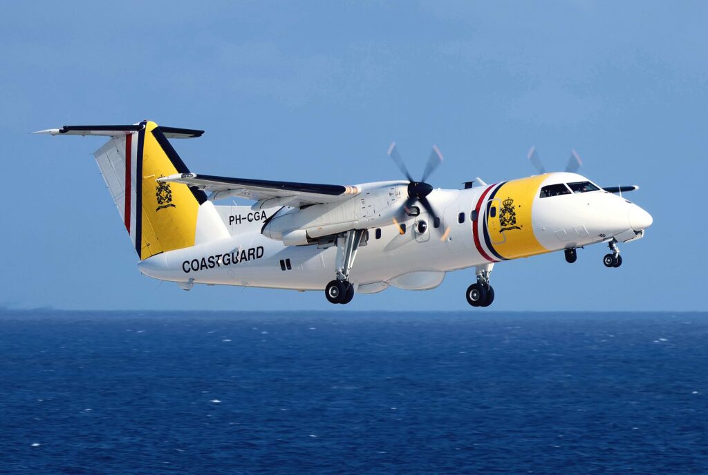 DCCG Dash 8-100 just after takeoff with landing gear still down. Blue ocean and blue sky in background