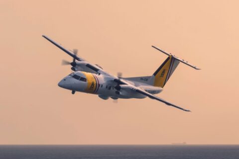 DCCG Dash 8-100 banks low with sunset in background