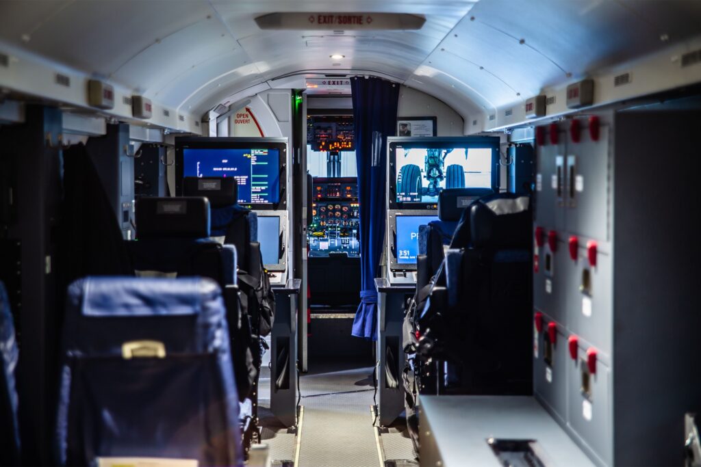 Operator workstations and mission displays installed along the cabin of a special mission aircraft.
